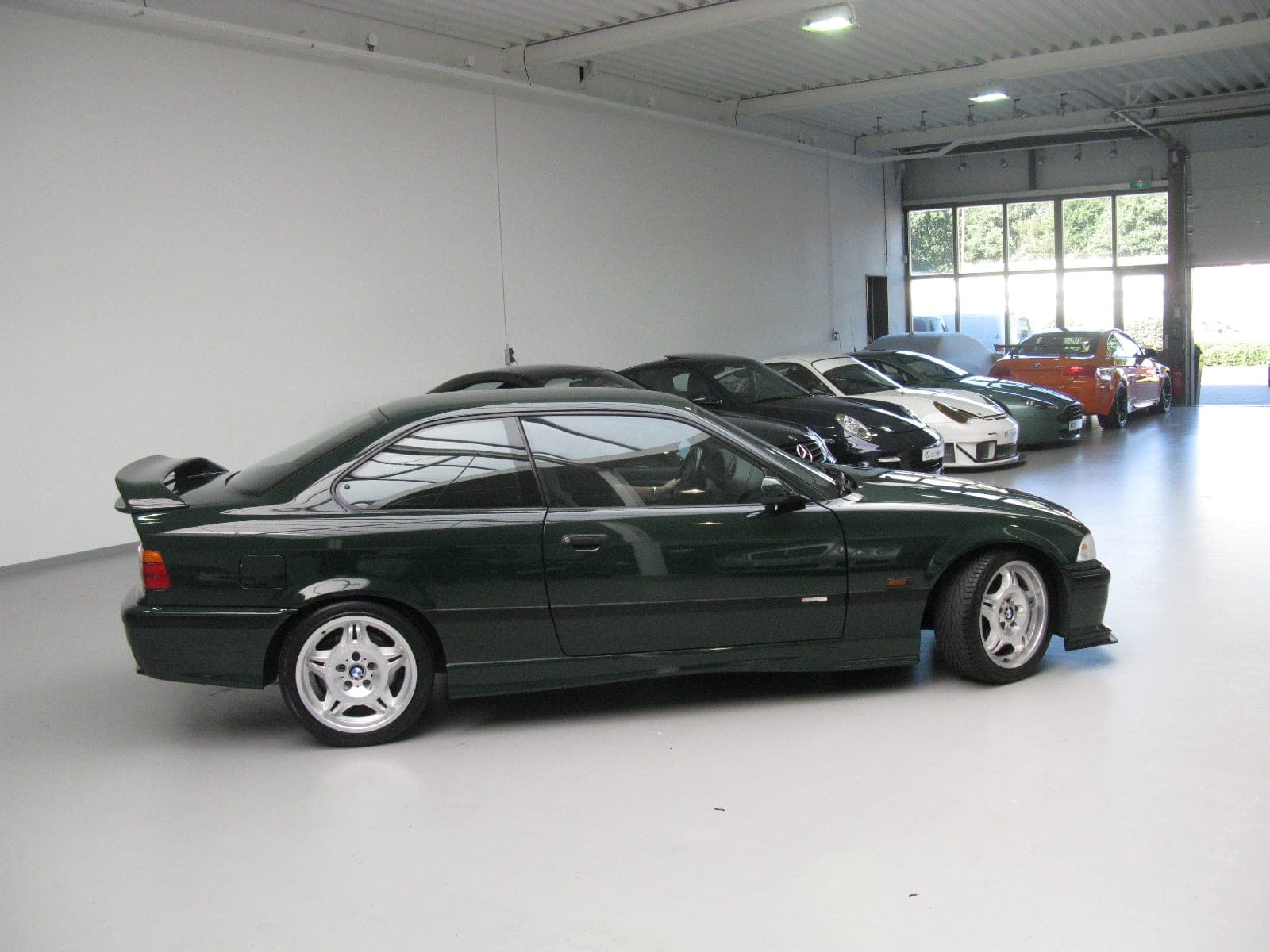 BMW M3 GT E36 en verde British Racing Green con el alerón trasero regulable, vista de tres cuartos trasera