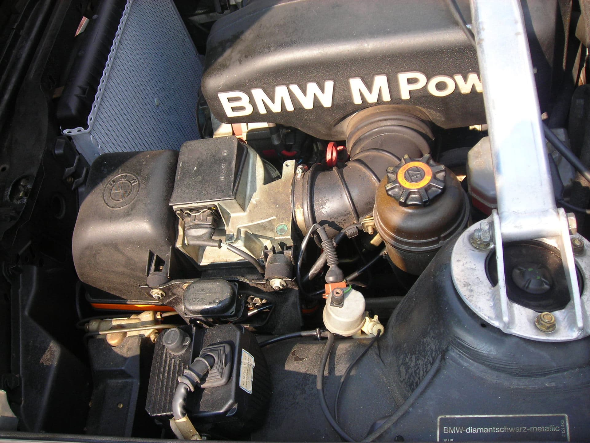 Motor BMW S14 en el vano de un M3 E30, con la tapa de balancines rotulada BMW M Power