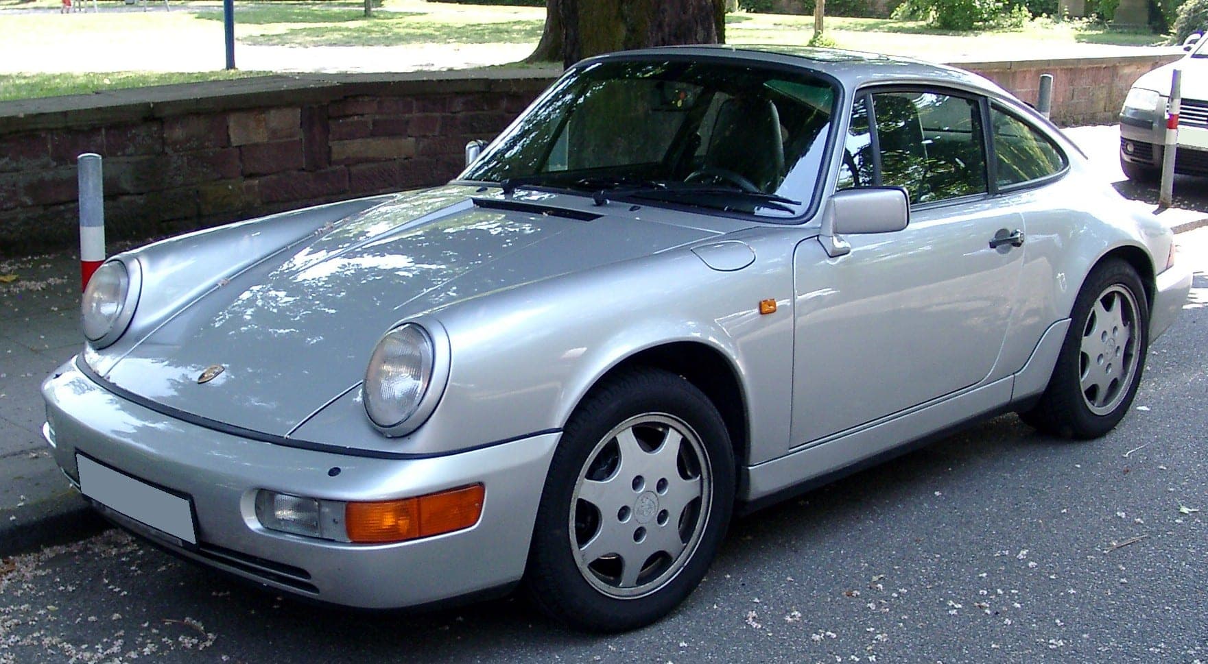 Porsche 911 964 plateado con los paragolpes integrados en color, vista de tres cuartos delantera